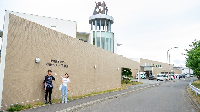 子ども食堂の方に売上金の一部を手渡す学生