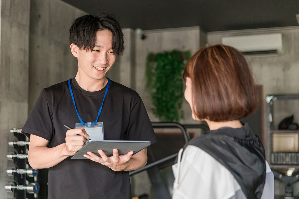 健康運動指導士が運動者にプログラムを説明している様子