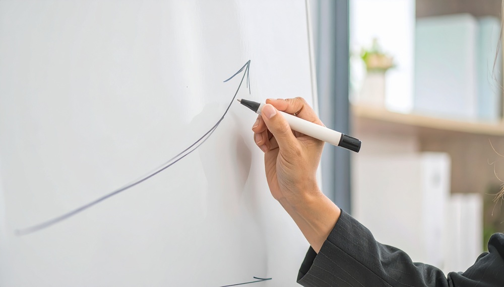 上向きに矢印を書く女性の手