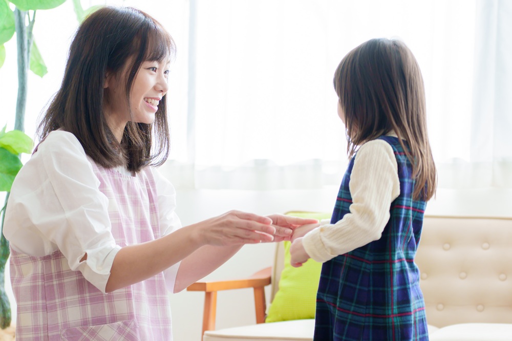 子どもと向かい合う女性