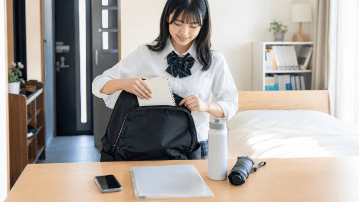 オープンキャンパスの持ち物をリュックに準備する高校生