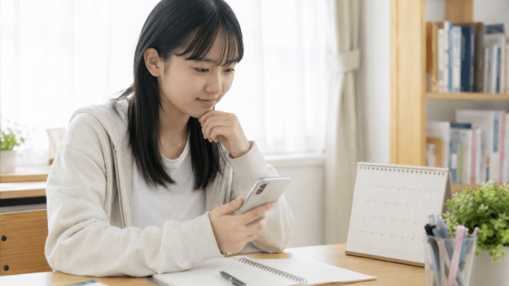 スマートフォンでオープンキャンパスの予約を確認する高校生