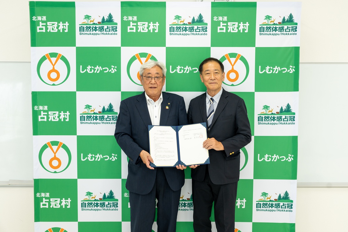 協定書を手にする田中村長（左）と蔵満学長（右）